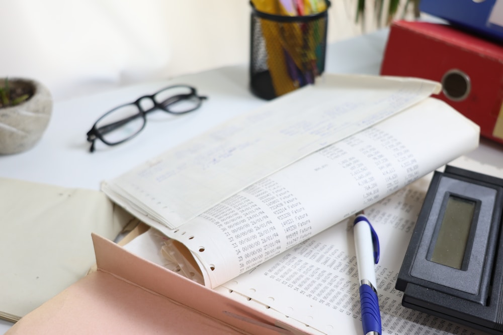 Calculator, glasses and financial paperwork on a desk